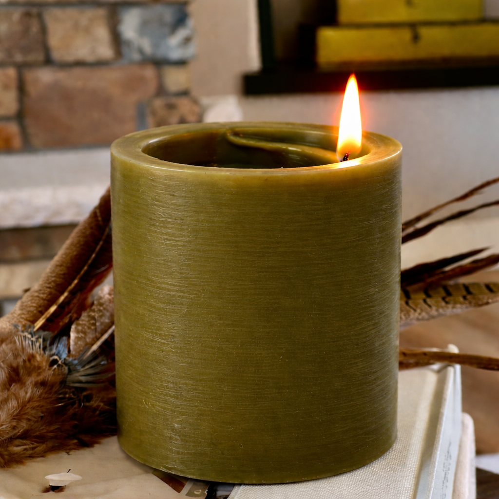 Green candle with a flame in front of a stone fireplace